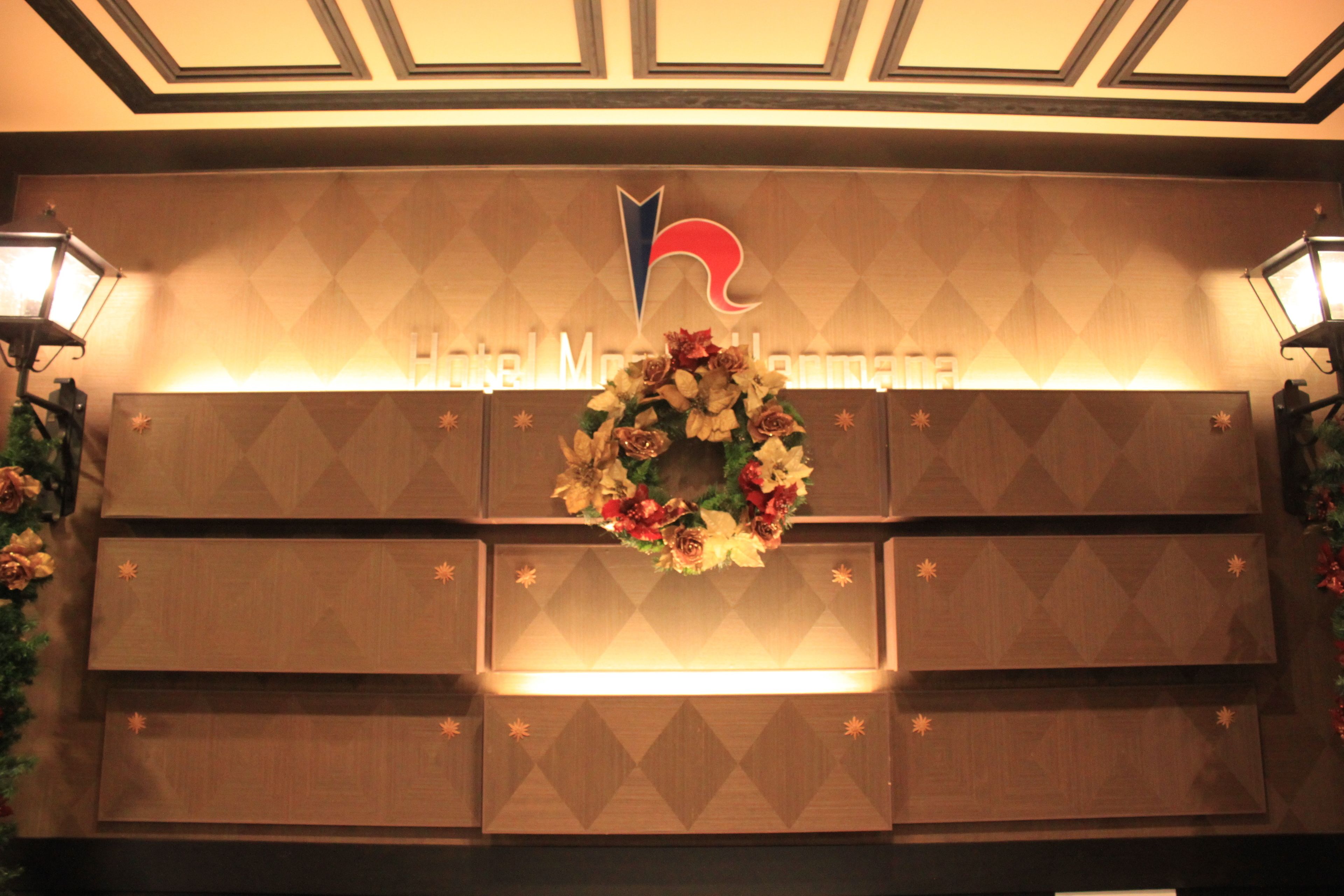 Uma área de recepção com uma coroa de flores, um logotipo e uma placa que diz 'Hotel Metropolarm'.