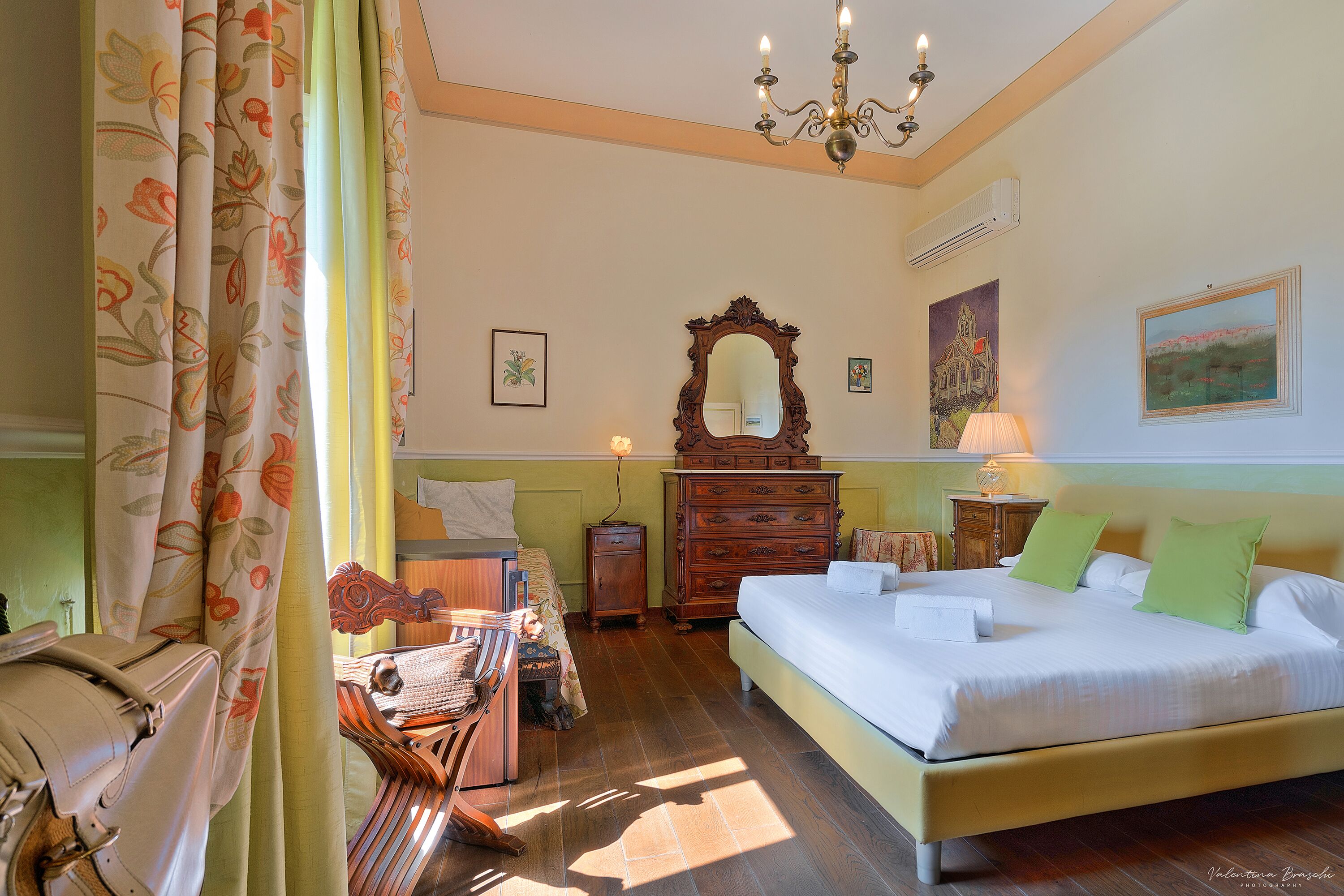 A bedroom with a bed, dresser, mirror, and a desk with a chair.
