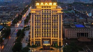 Un hotel de gran altura con una entrada destacada y un letrero grande en la parte superior.