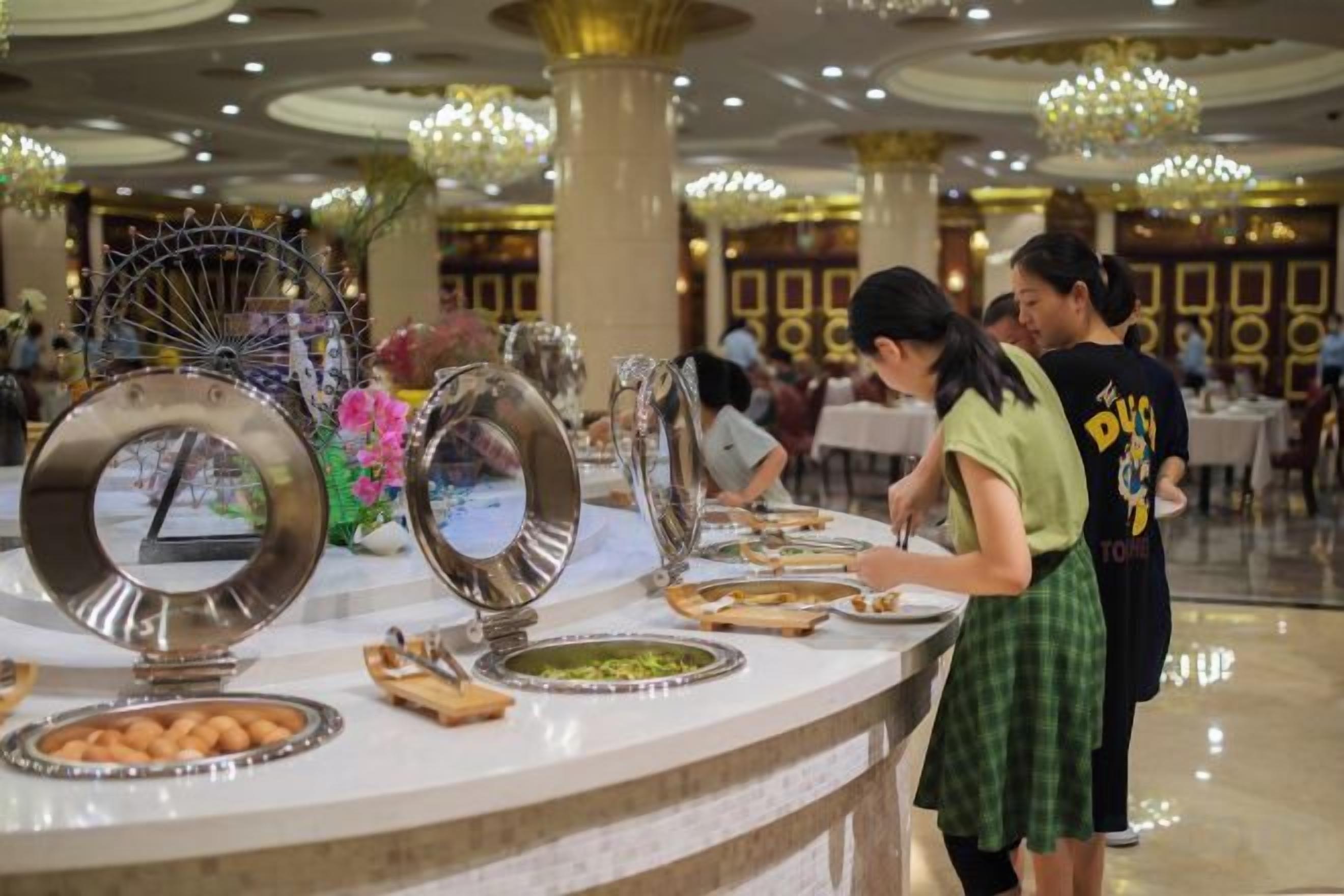 A buffet setup with various dishes and a decorative mirror.