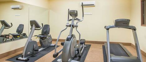 A gym with treadmills, elliptical machines, and stationary bikes.