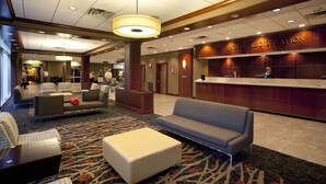 A hotel registration area with a reception desk, seating area, and a carpeted floor. - The University of Georgia Center for Continuing Education & Hotel (Athens)