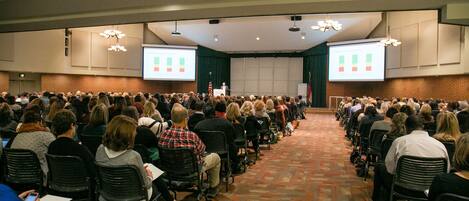 A conference room with rows of chairs facing a presentation screen.