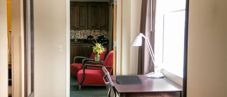 Una habitación de hotel con escritorio, silla y vistas a la cocina.