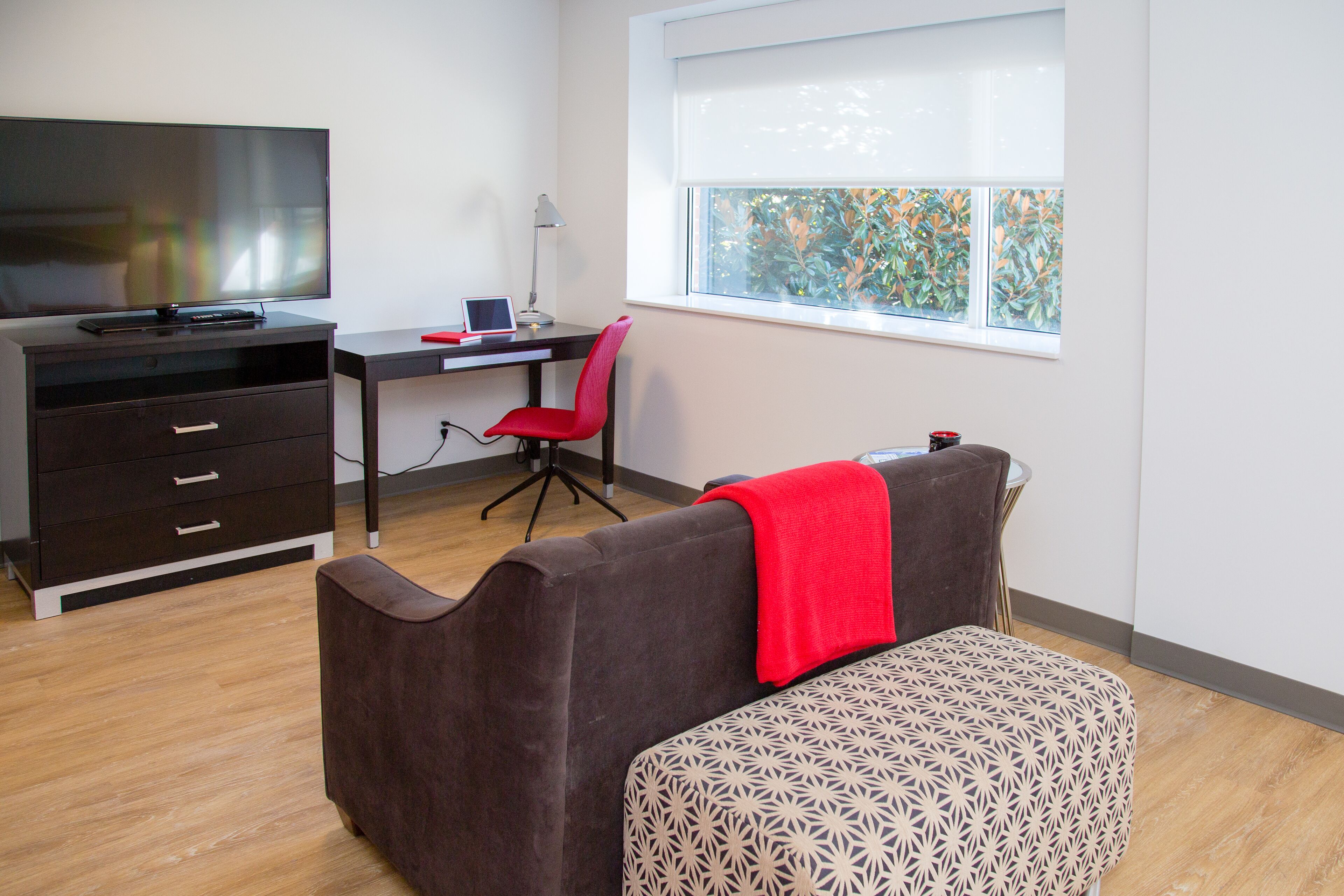 A modern room with a desk, chair, and a television.