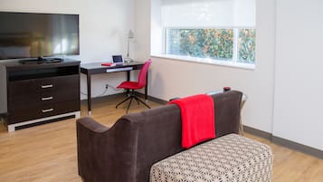 Habitació moderna amb escriptori, cadira i televisió.