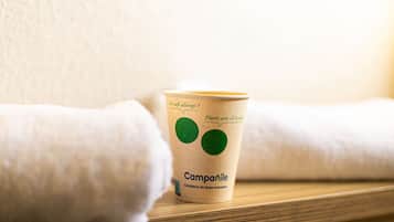 Una taza de papel con un logo y texto sobre una superficie de madera.