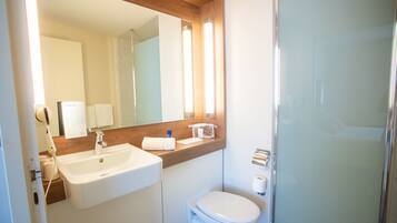 A modern bathroom with a sink, toilet, and shower.