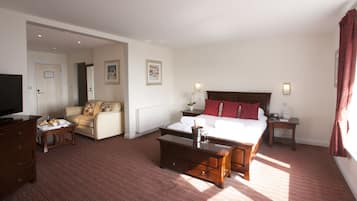 Ein Hotelzimmer mit einem Bett, einer Couch, einem Fernseher, einem Couchtisch und einer Kommode.