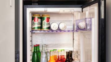 Un réfrigérateur rempli de diverses boissons, notamment de la bière, des sodas et de l’eau.