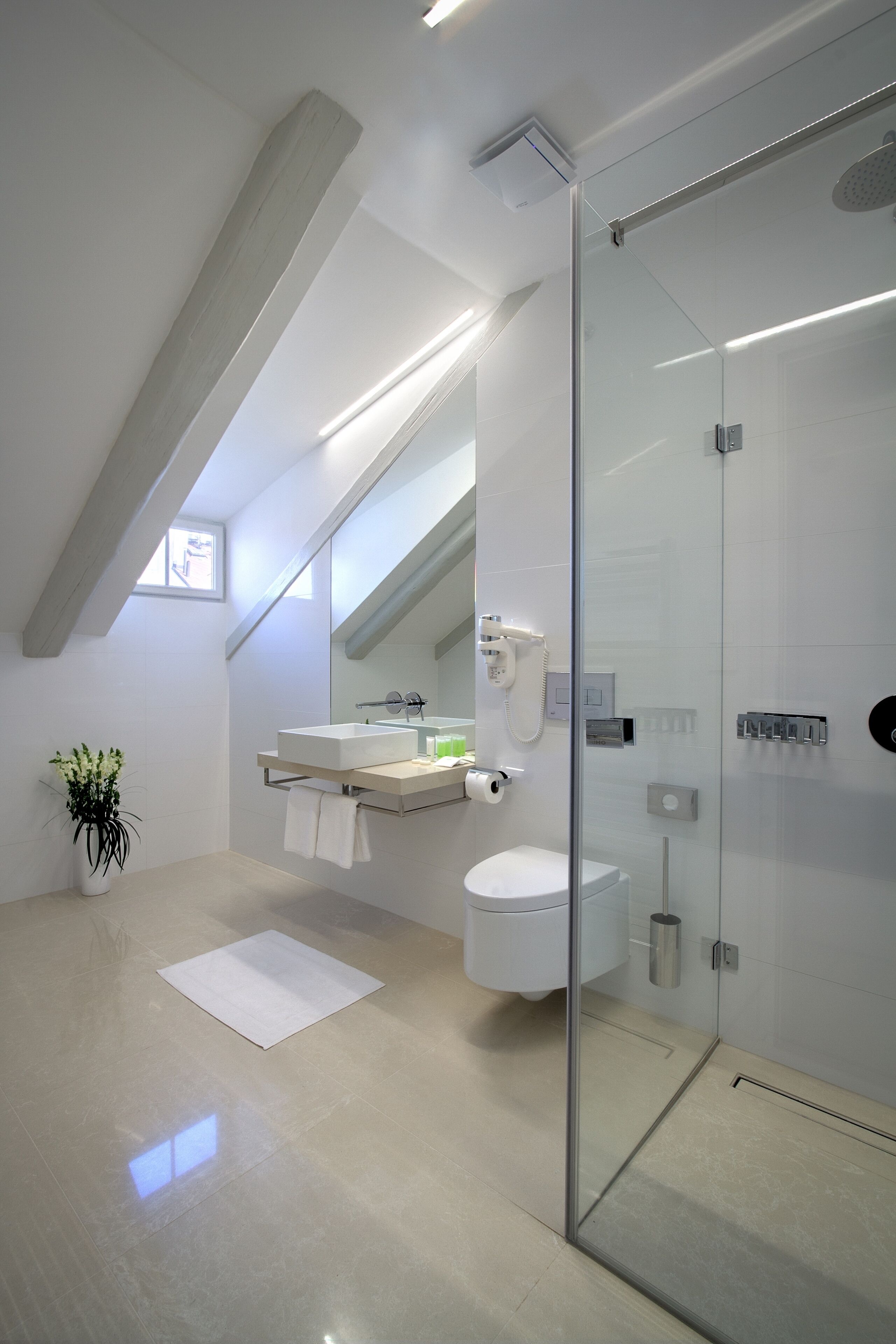Ein modernes Badezimmer mit einer Duschkabine aus Glas, einem weißen Waschbecken und einer Toilette.