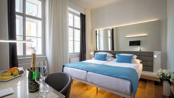 Habitación de hotel con cama, mesita de noche y ventana con cortinas.