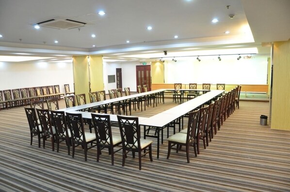 A conference room with a long table and chairs, carpeted floor, and a large window.