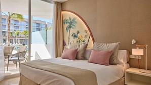 Une chambre d’hôtel avec un grand lit, une table de chevet avec une lampe, une vue sur la piscine et une fresque murale.