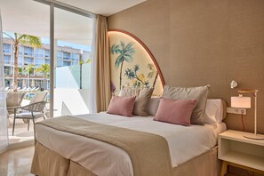 Habitación de hotel con una cama grande, una mesita de noche con lámpara, vista al área de la piscina y un mural en la pared.