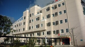 A multi-story hotel with a modern design, featuring a prominent signage at the top and a visible entrance with a glass facade. - Jinjiang Inn Shanghai Zhangjiang Road (Shanghai)