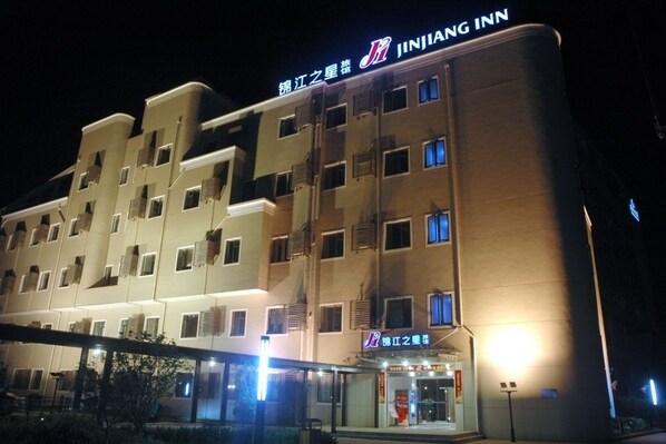 A multi-story hotel with a prominent signage for JINJIANG INN.