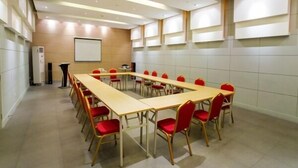 A conference room with a long table, red chairs, a projector screen, and a podium. - Jinjiang Inn Shanghai Lujiazui (Shanghai)