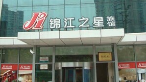 A hotel with a modern glass facade and a prominent red and white logo. - Jinjiang Inn Shanghai Lujiazui (Shanghai)