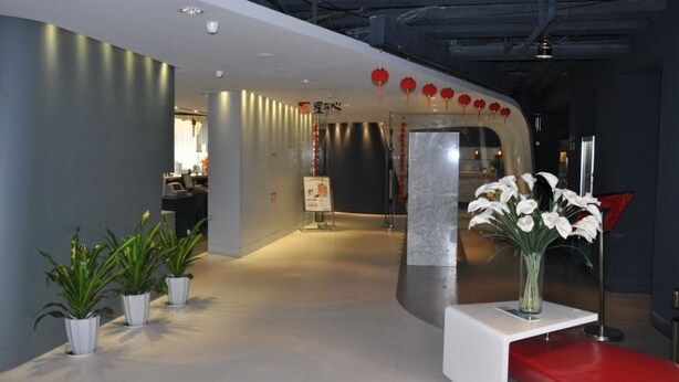 A modern reception area with a curved wall, a reception desk, and potted plants. - Jinjiang Inn Shanghai Expo Park Pusan Road (Shanghai)