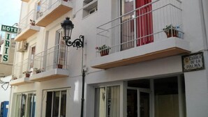 Un hôtel à plusieurs étages doté de balcons, un panneau de signalisation et une enseigne indiquant une « Carrera de la Palma ».