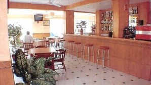 Un restaurant doté d’un bar, de plusieurs tables et de chaises.