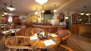 Een restaurant met houten tafels en stoelen, een bar en hangende吊灯