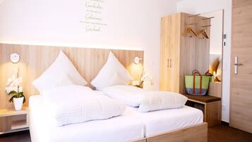 Un dormitorio moderno con cama de madera, mesitas de noche, un armario y un espejo.