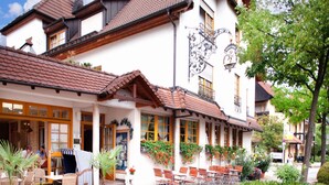 Il s’agit d’un bâtiment européen traditionnel, doté d’un toit en pente, de nombreuses fenêtres et d’un balcon avec des sièges pour l’extérieur.