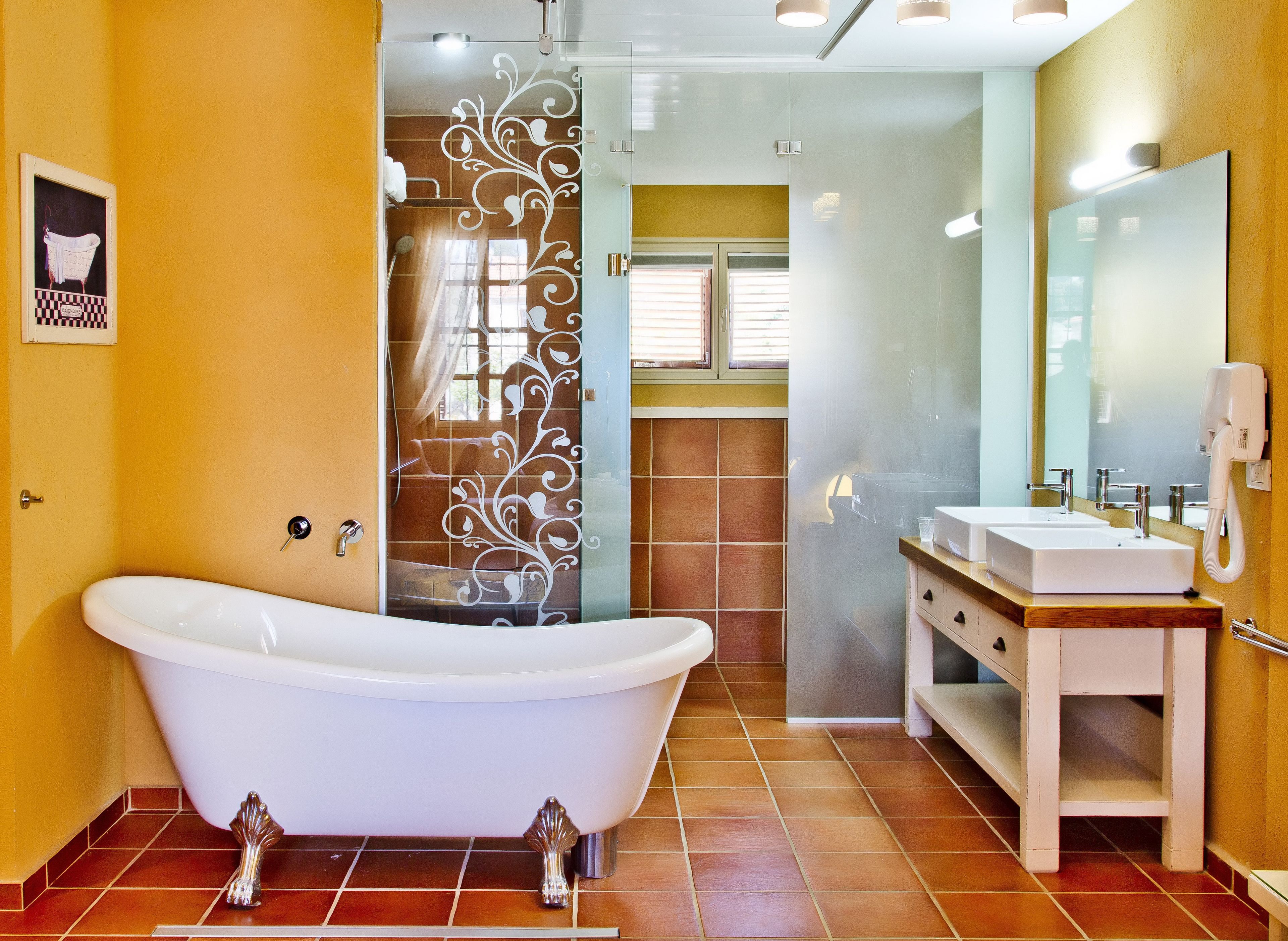 A bathroom with a freestanding bathtub, a vanity with a mirror, and a shower area with a glass door.