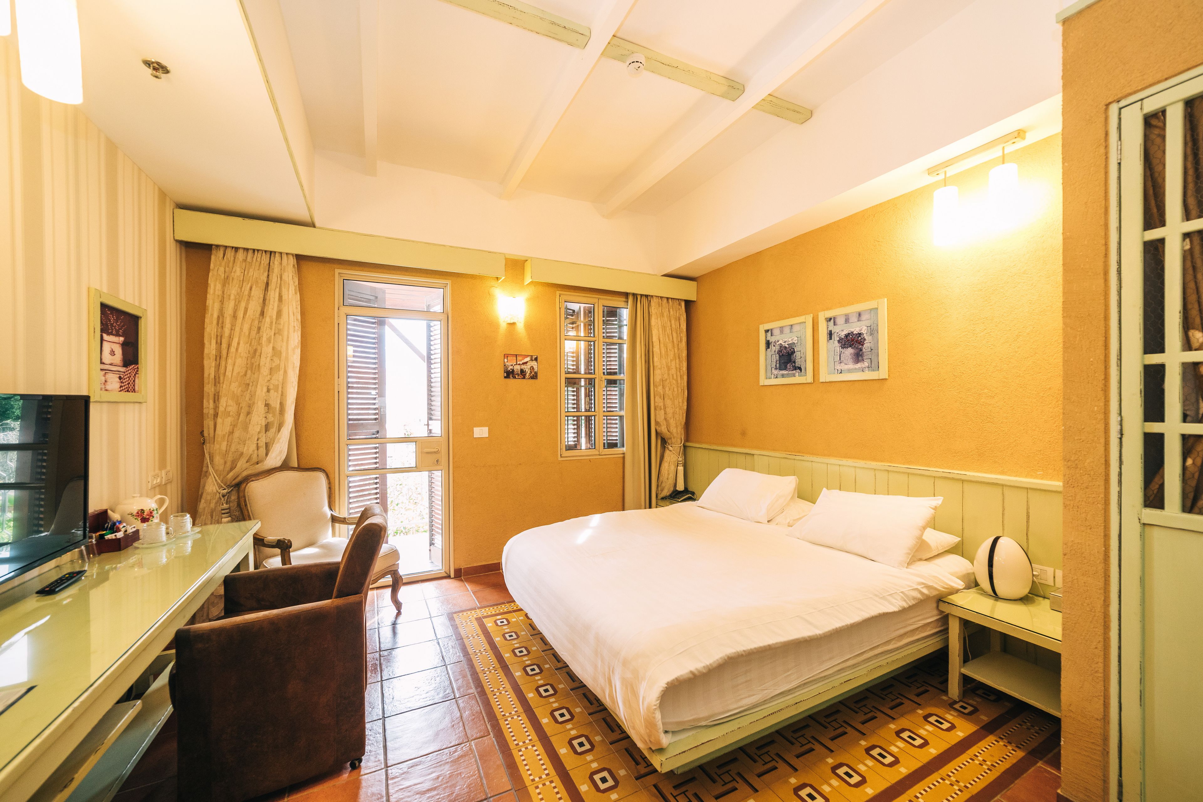 Una habitación de hotel con cama, escritorio, silla y televisión.