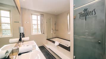 A modern bathroom with a bathtub, shower, and vanity.