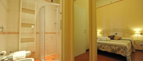 A bathroom with a shower, toilet, and sink.