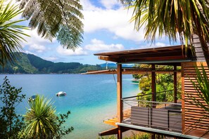 A wooden deck with a view of a lake and mountains.
