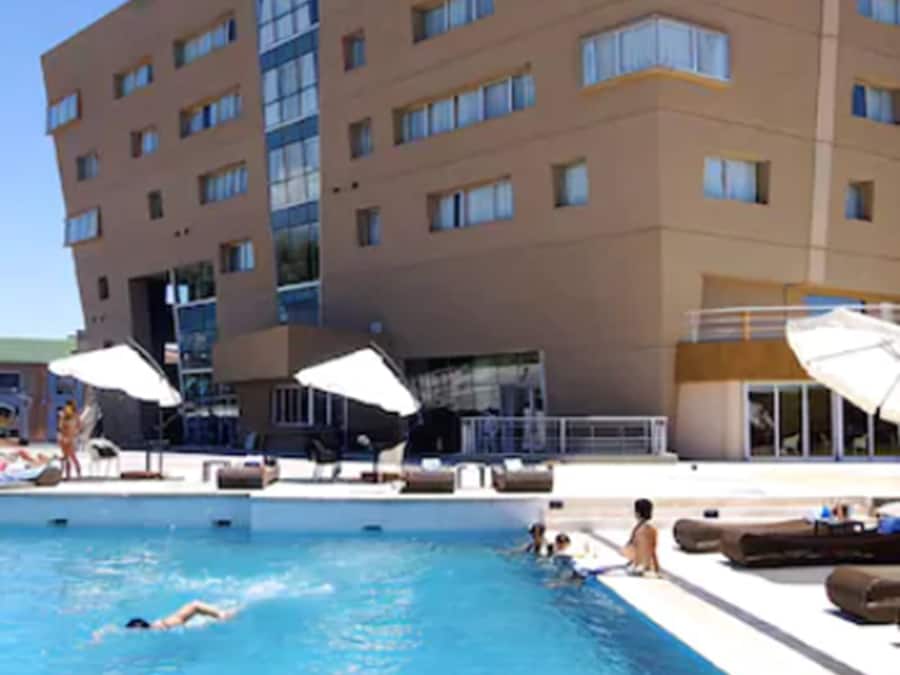 Una piscina al aire libre de temporada, sombrillas
