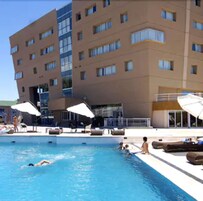 Una piscina al aire libre de temporada, sombrillas