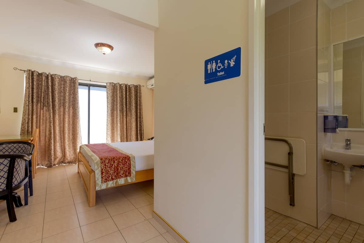 Una habitación de hotel con cama, escritorio y baño.