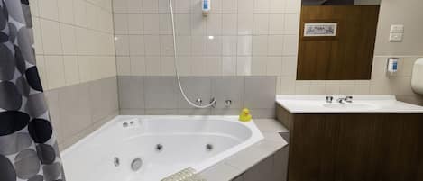 A bathroom with a bathtub, a shower, a sink, and a toilet.