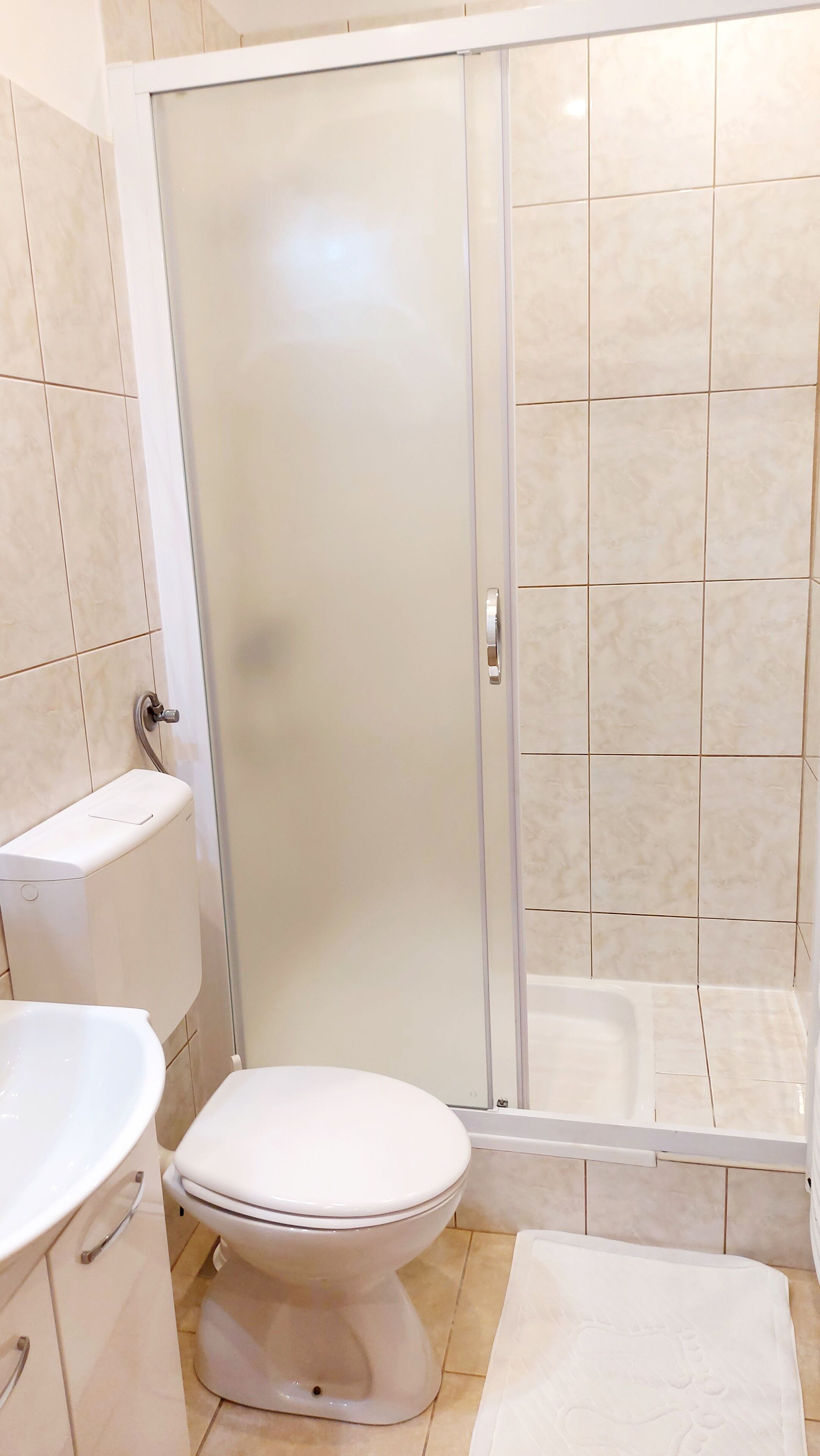A bathroom with a toilet, a shower enclosure, and a bathtub.