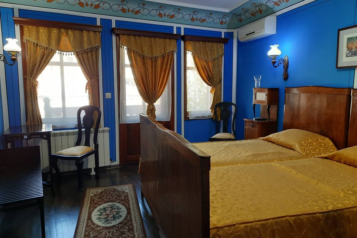 Une chambre avec deux lits, un bureau et une chaise.