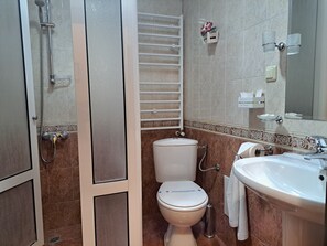 A bathroom with a shower, toilet, and sink.