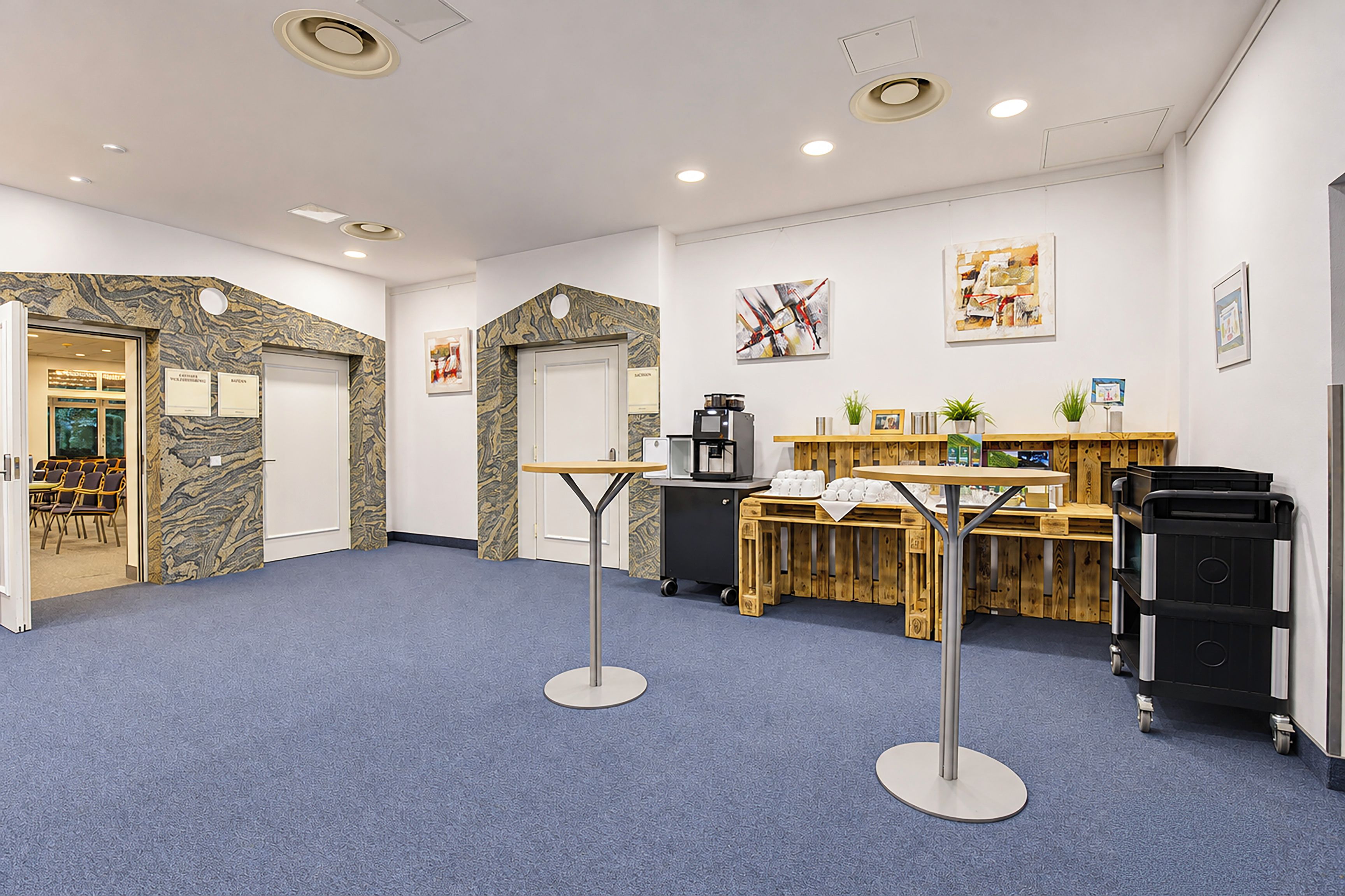 A reception area with a coffee machine, a counter, and a seating area with chairs.