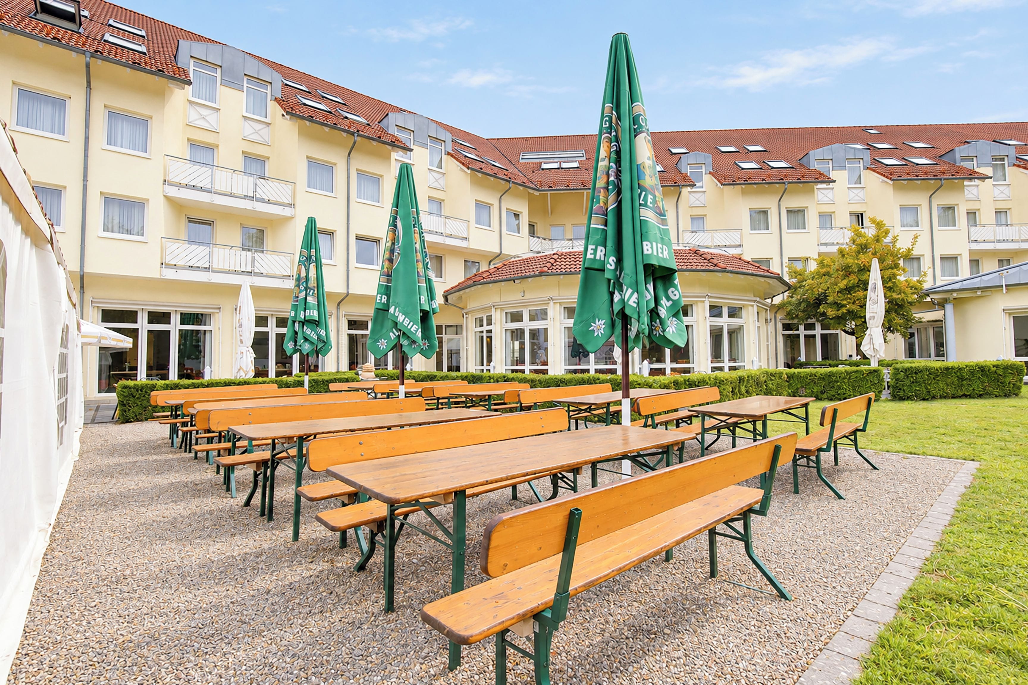 A courtyard with outdoor seating and a building with multiple balconies in the background.