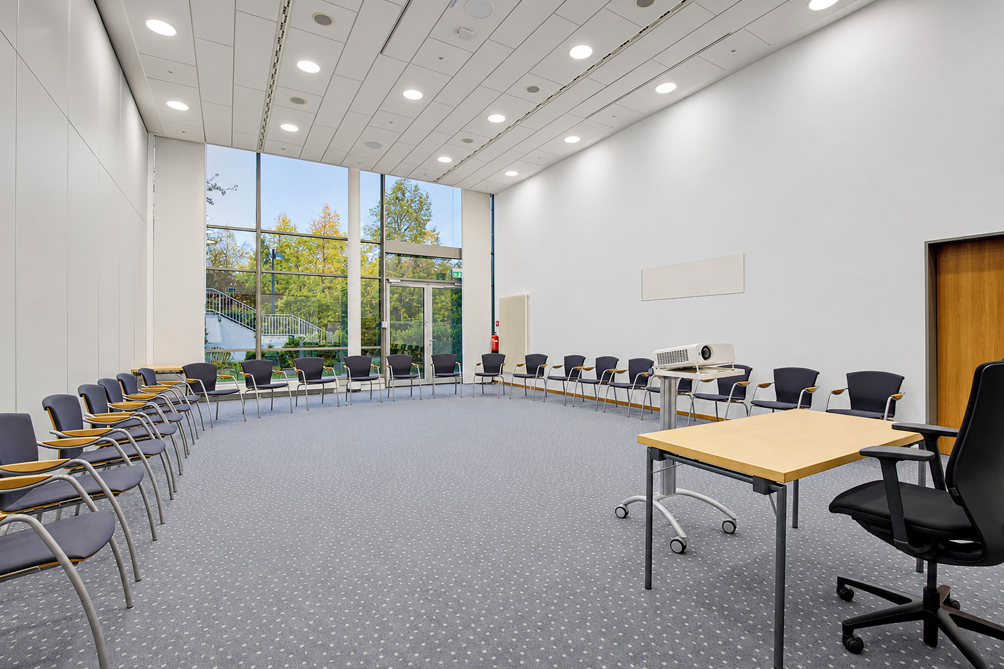 A conference room with a long table, chairs, and a projector.