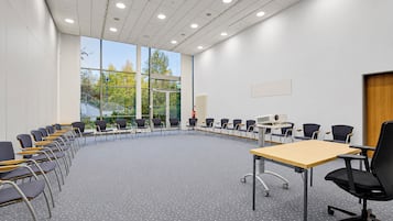 A conference room with a long table, chairs, and a projector.