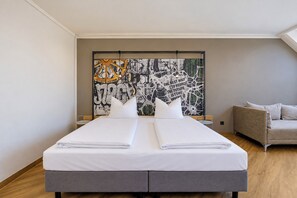 Una habitación de hotel con una cama, un sofá y un cuadro abstracto grande en la pared.