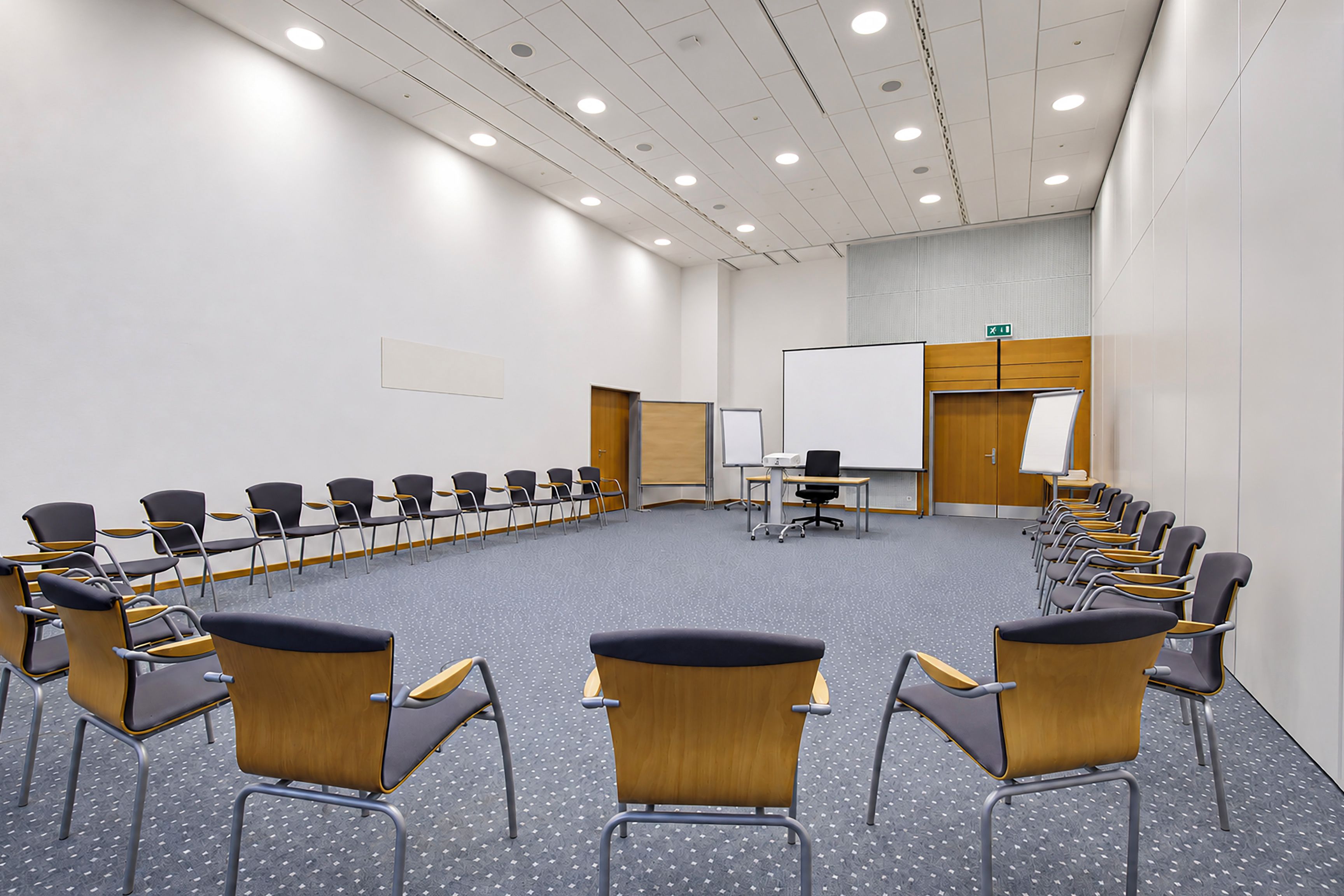 A conference room with a long table, chairs, a whiteboard, and a projector.