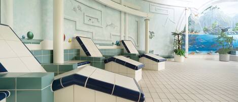 A spa area with multiple seating areas, a tiled floor, and a mural depicting a natural scene.