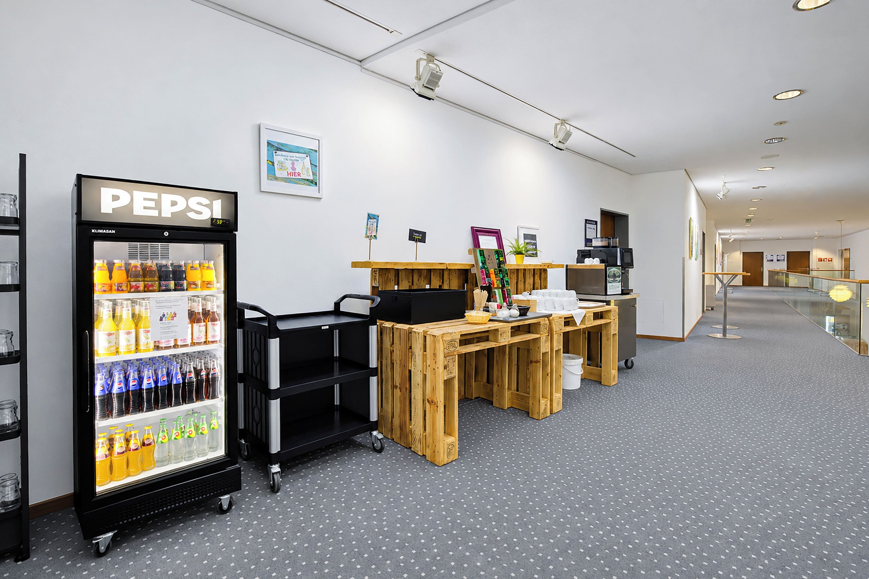 Een modern interieur met een automaat voor drankjes, houten tafels en een schoon, minimalistisch ontwerp.