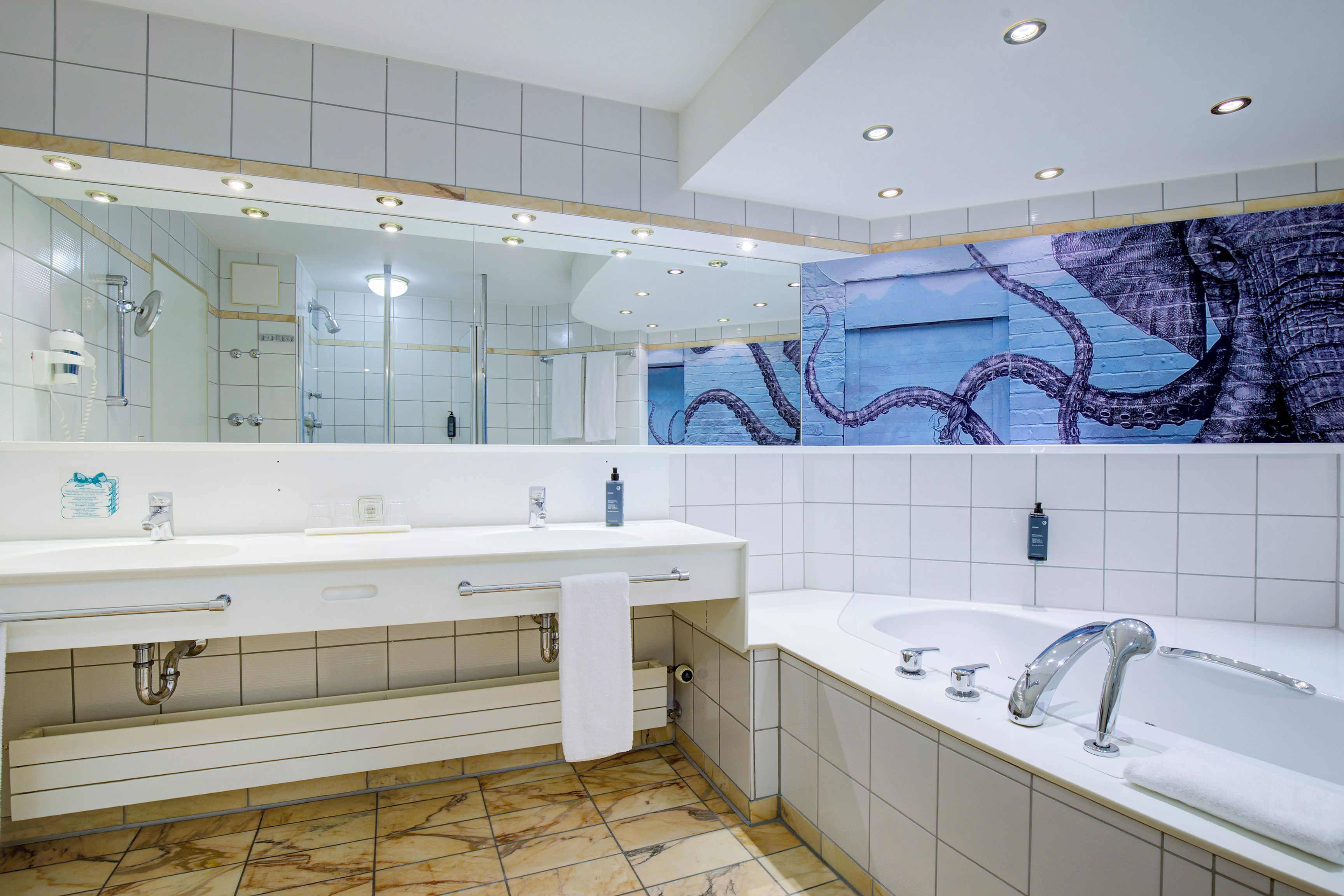 A modern bathroom with a large mirror, a bathtub, and a shower area.